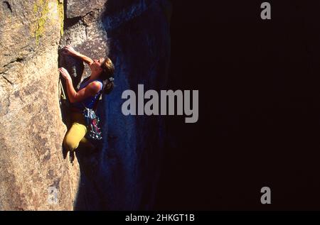 Female rock climber climbing a difficult route at Windy Point. Santa Catalina Mountains, Arizona Stock Photo