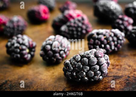Frozen Blackberries on a Sheet Pan: Closeup view of frozen berry fruit on a metal baking pan Stock Photo