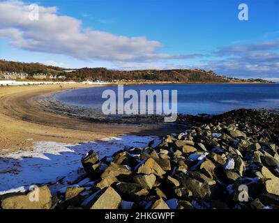 A view along the fine sandy beach in the Fife coastal town of Burntisland during a bright but cold winters day. Stock Photo