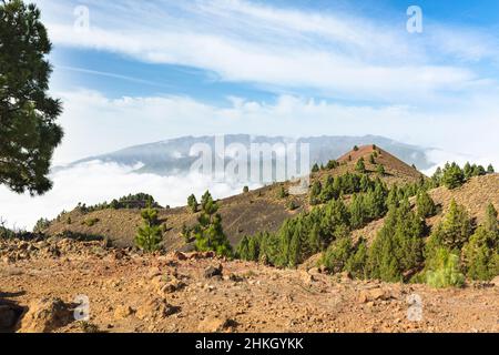 View from the Montana la Barquita in red lava landscape on the Cumbre Vieja in La Palma, Spain with the Pico Birigoyo in the background. Stock Photo