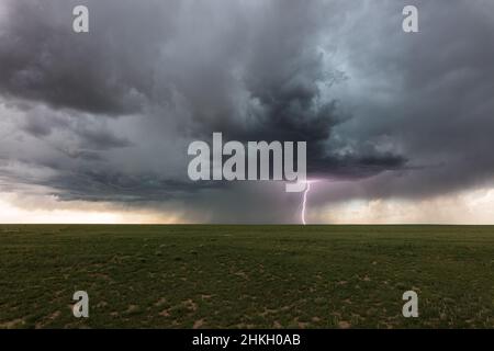 Scenic landscape with dark clouds and a lightning strike from a summer storm in the plains near Kim, Colorado Stock Photo