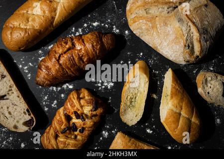 bakery - pastry assortment on black background with flour. top view Stock Photo