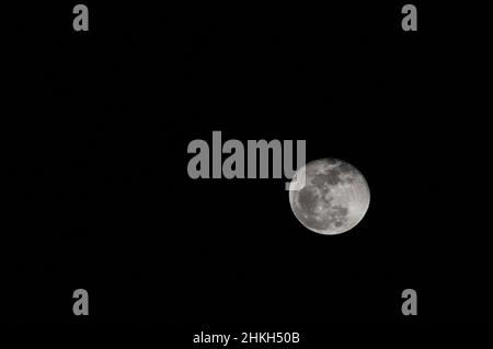 Moon at almost full phase against a black sky, taken with a 400mm lens on a crop frame camera on a tripod. Stock Photo