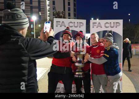 Manchester United fans pose with a replica FA Cup trophy outside the ground before the Emirates FA Cup fourth round match at Old Trafford, Manchester. Picture date: Friday February 4, 2022. Stock Photo