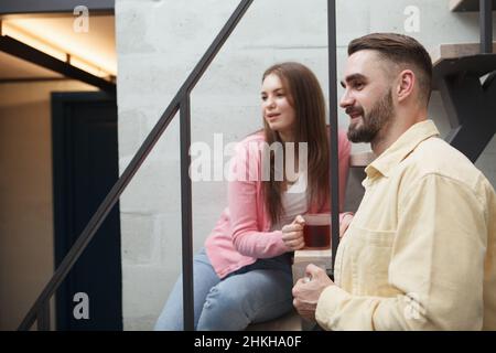 Beautiful couple watching tv at home while having tea together Stock Photo