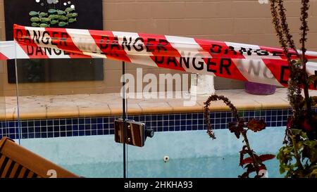 Danger tape blocking off swimming pool under construction or repair Stock Photo