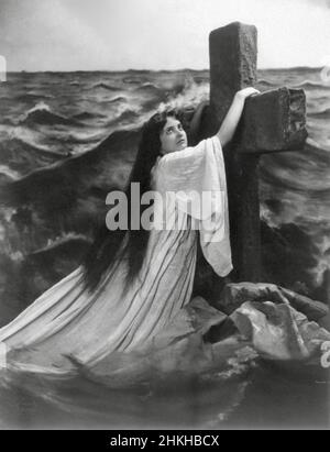 Fitz W Guerin, American photographer - Young Woman Hanging on to a Cross in Sea Stock Photo