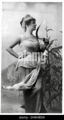 Fitz W Guerin, American photographer - Young Woman holding a Sickle with Corn Stalk in the Background Stock Photo