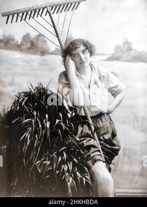 Fitz W Guerin, American photographer - Young Woman Modelling - Standing with a Rake - 1902 Stock Photo