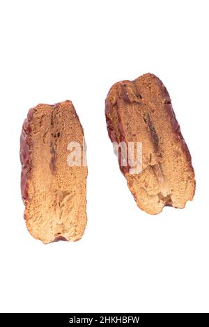 Dried dates cut into two halves on a white background. Top view of date halves. Stock Photo