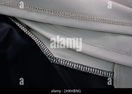 Overlock for fabric and knitwear. Overlock stitch close-up. Finishing the edges of the fabric for the dress. Tailoring. Seams on a polyester dress top Stock Photo