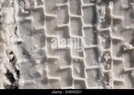 Texture of a car wheel on wet snow. Wet snow on the road top view. Road covered with snow close-up. Wet snow danger. Not cleaned roads in bad weather, Stock Photo