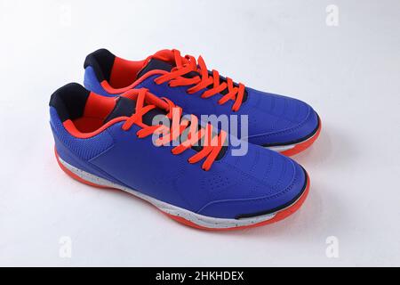 Football sneakers with bright laces on a white background. blue sports shoes with orange laces and a white sole. bright football pair of shoes on a wh Stock Photo