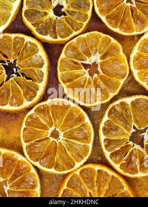 Dried sliced oranges top view background. Dried citrus fruits at home. Fruit chips close up. Stock Photo