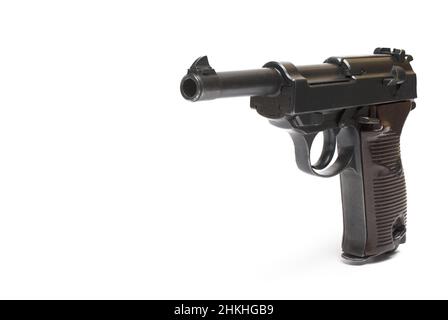 side view Close up of an older classic semi-automatic pistol with wooden grip panels on the grip and black barrel on white background Stock Photo