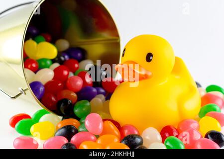 An rubber duck surrounded by assorted jelly beans from spilled pail.  Close up view. Stock Photo