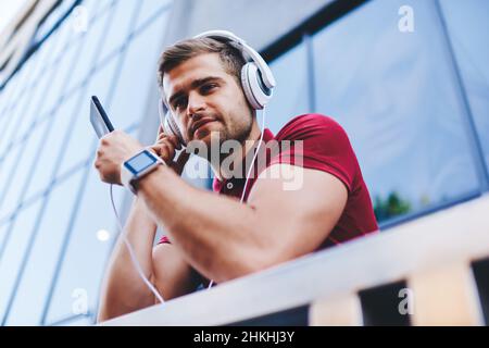 Happy man enjoying music on balcony Stock Photo