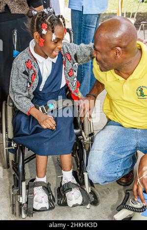 Miami Florida,Liberty City,Lenora Smith Elementary School,Black man teacher disabled girl student wheelchair Stock Photo