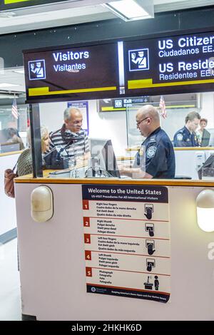 Miami Florida International Airport MIA,Passport Control,Customs agent booth,arriving travelers passengers entering welcome United States sign Stock Photo