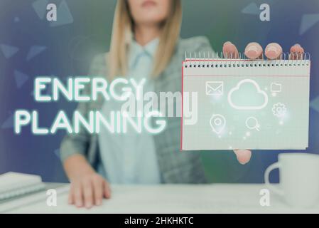 Conceptual caption Energy Planning. Business concept making of a strategy and plan for the consumption of energy Lady Pressing Screen Of Mobile Phone Stock Photo