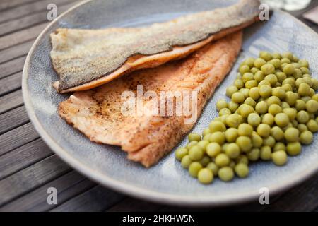 Appetizing baked trout fillets with green peas Stock Photo