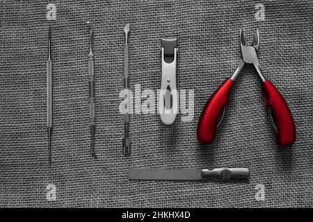 nail care utensils color on black and white on a burlap background Stock Photo
