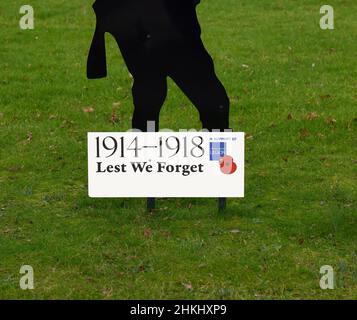 War memorial of a black metal cut out of a soldier with a rifle and the words 'Lest we forget'. Stock Photo