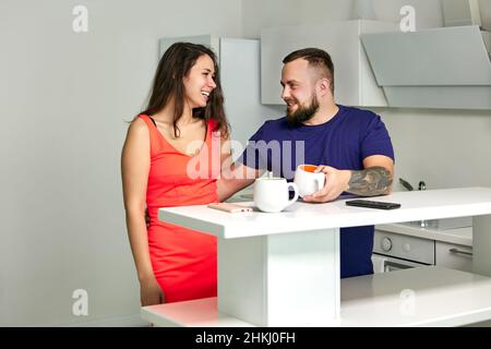 Flirt in office kitchen between colleagues during break. Stock Photo