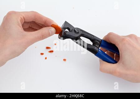 Using nippers to shape edge on piece of ceramic tile Stock Photo