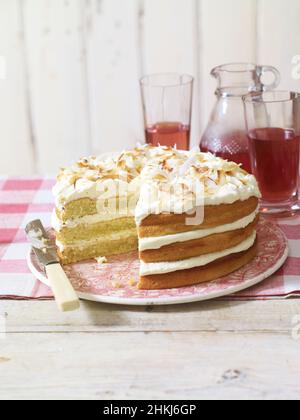 Triple-layered coconut cake decorated with shredded coconut Stock Photo