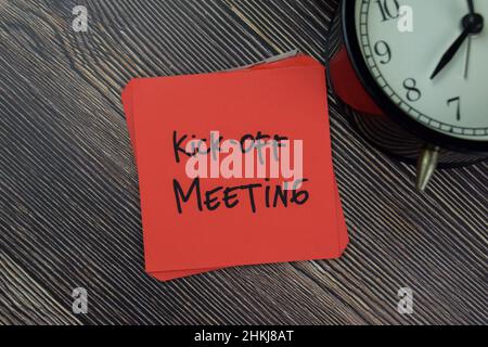 Kick-off Meeting write on sticky notes isolated on Wooden Table. Stock Photo