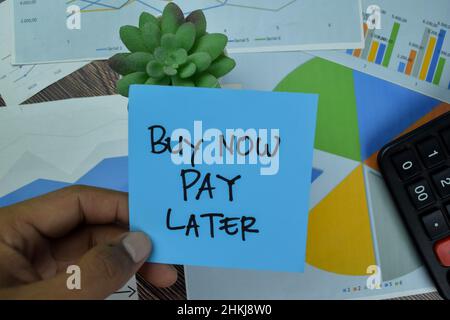 Buy Now Pay Later write on sticky notes isolated on Wooden Table. Stock Photo