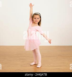 Girl in ballerina outfit holding one arm up Stock Photo