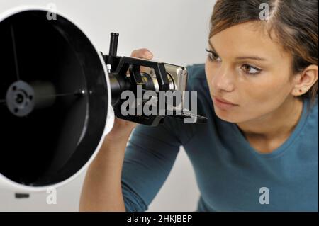 Woman using camera to take photos through telescope lens Stock Photo