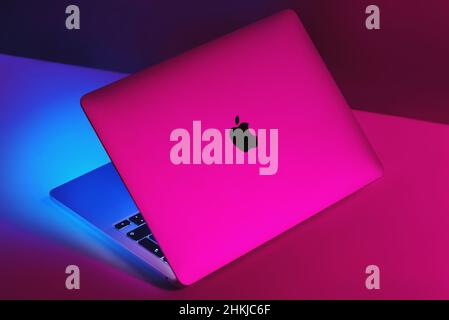 Izmir, Turkey - January 10, 2022: Half opened Apple Brand M1 Model Macbook pro laptop computer with purple and blue colored lights Stock Photo