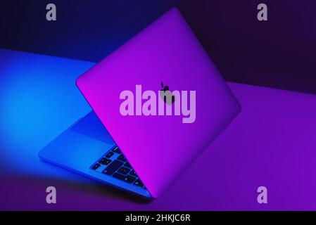 Izmir, Turkey - January 10, 2022: Half opened Apple Brand M1 Model Macbook pro laptop computer with purple and blue colored lights Stock Photo