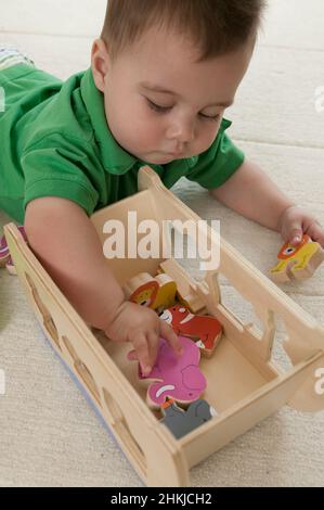 Baby boy lying on the floor playing with toys Stock Photo
