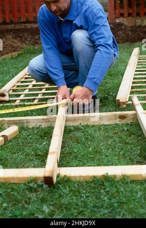 Man measuring wood with tape measure Stock Photo