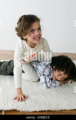 Girl sitting on boy Stock Photo
