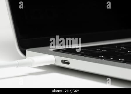 Close up shot of usb c cable plugged to a laptop computer. Stock Photo