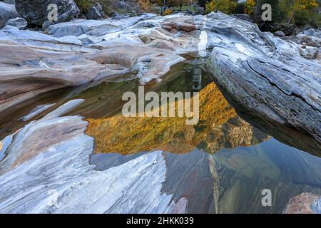 Lavertezzo church reflected in water surface between rocks on the river, Valle Verzasca, Switzerland, Ticino Stock Photo