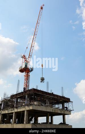 Crane lifting concrete container on construction site Stock Photo