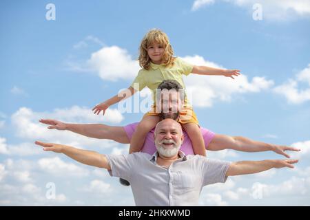 Family meeting. Father and a boy came to see his grandfather raising hands or open arms flying on sky. Stock Photo