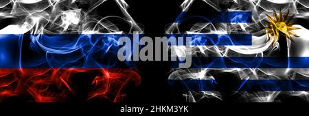 Russia, Russian vs Uruguay, Uruguayan flags. Smoke flag placed side by side isolated on black background. Stock Photo