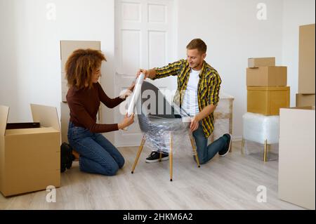 Couple wrapping chair before renovating living room Stock Photo