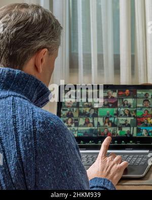 A man in quarantine uses technology to videoconference with other people Stock Photo