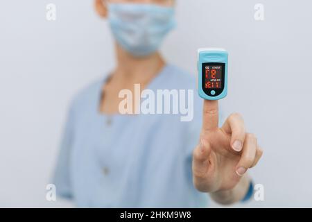 Pulse oximeter with hand of doctor isolated on white. The concept of portable digital device to measure person's oxygen saturation. Measuring oxygen Stock Photo