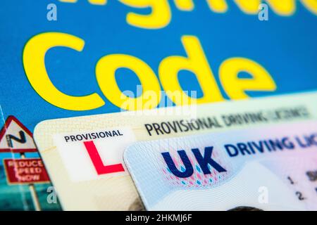 UK Driving Licence. Provisional and Full licence cards placed on Highway Code book. Macro. Stafford, United Kingdom, January 30, 2022. Stock Photo
