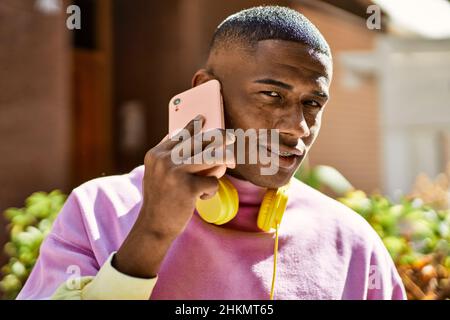 Young african american man smiling happy talking on the smartphone at the city. Stock Photo