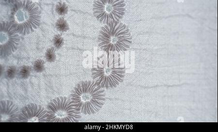 White floral embroidery on white colored fabric for dress, extremely detail embroidery pattern, selective focus Stock Photo